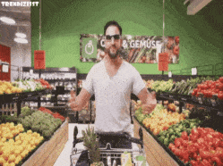un homme fait ses courses au rayon fruits et légumes