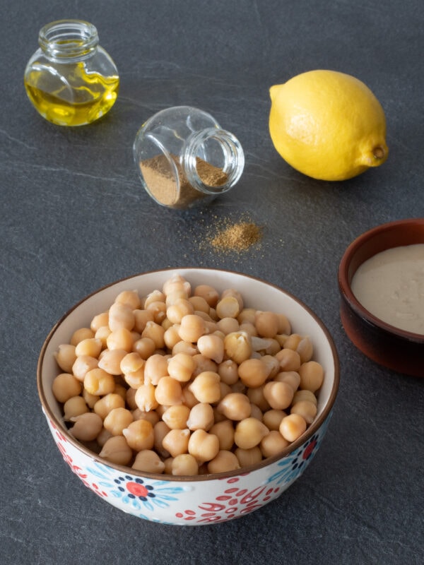 les ingrédients de la recette de houmous pois chiches purée de sésame tahin citron épices cumin paprika et huile d'olive