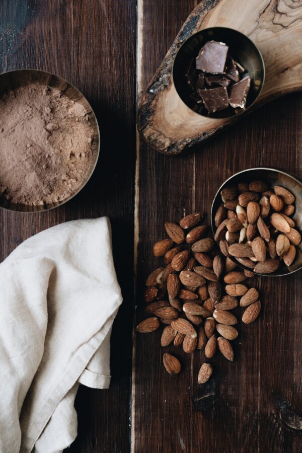 amandes poudre de cacao et chocolat sur une table en bois