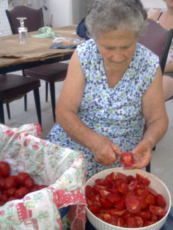 Mamma italienne coupant des tomates pour préparer une sauce bolognaise maison