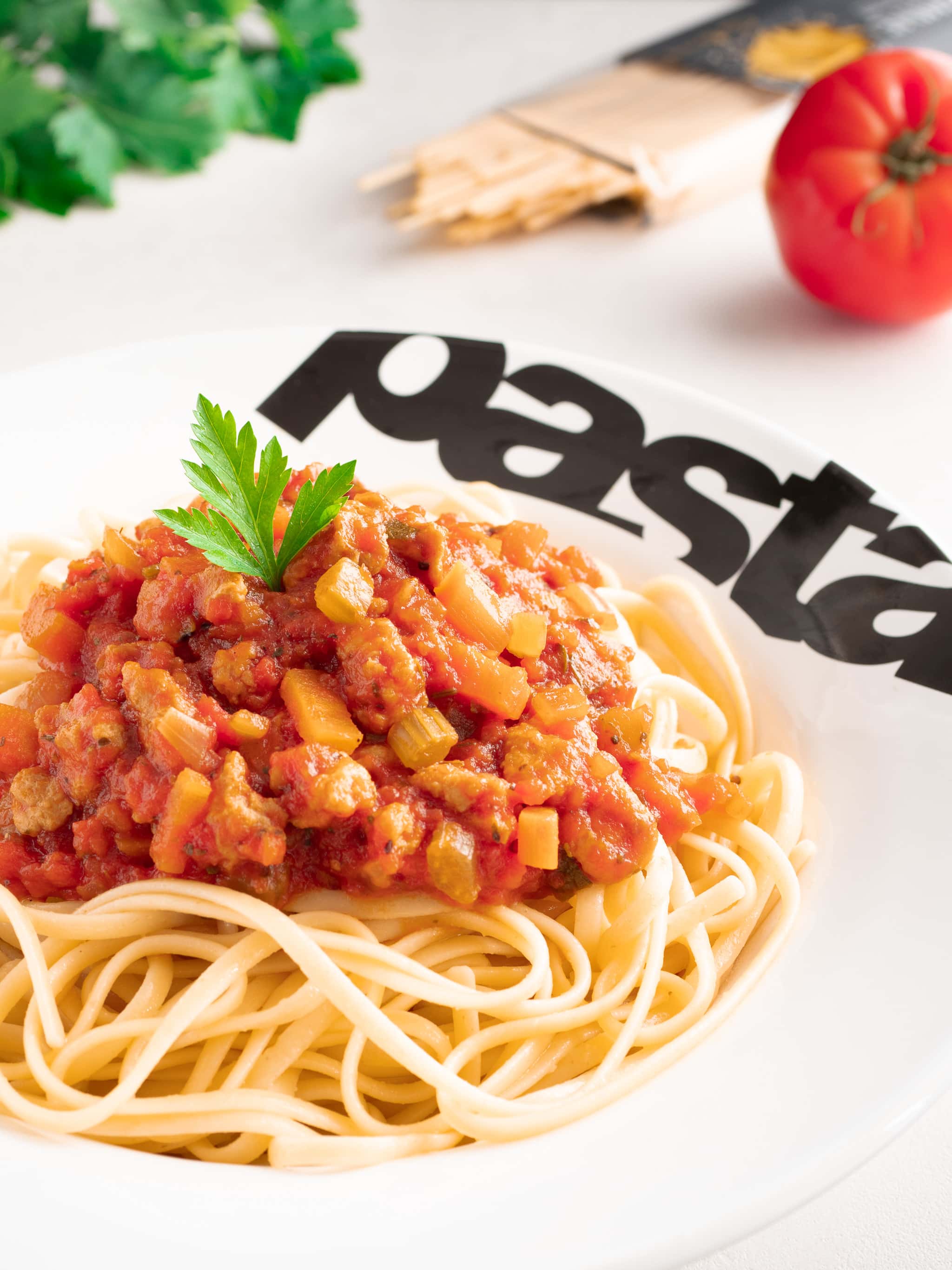 un plat de spaghetti avec une sauce bolognaise dans une assiette à pâtes