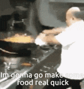 un cuisinier remue un wok géant
