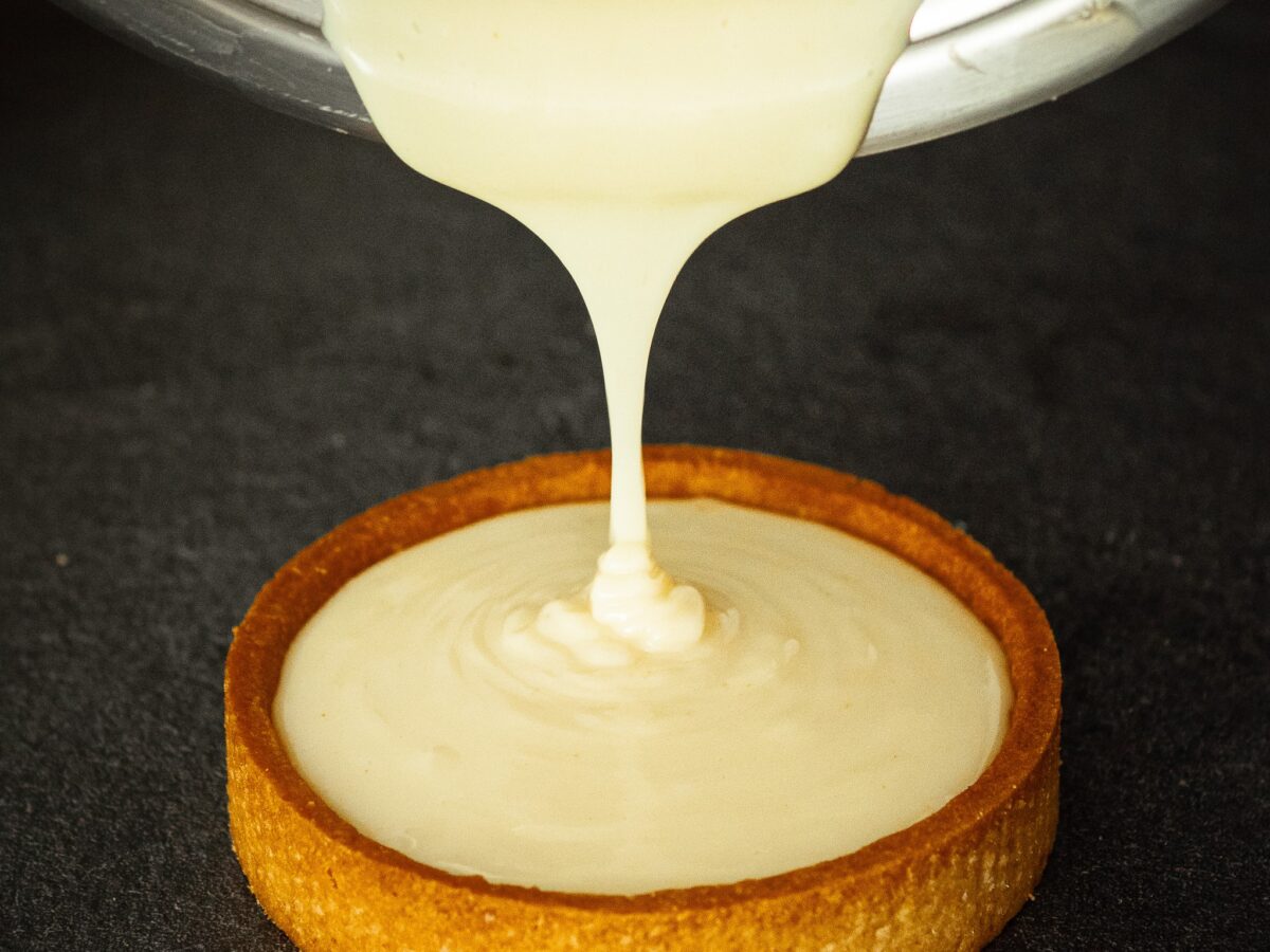 crème pâtissière sans oeufs versée dans un fond de tarte en pâte sablée vegan
