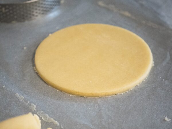un disque parfait est découpé dans la pâte à l'aide du cercle à tarte en emporte-pièce