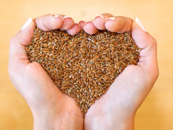 des mains pleins de graines de lin forment un coeur