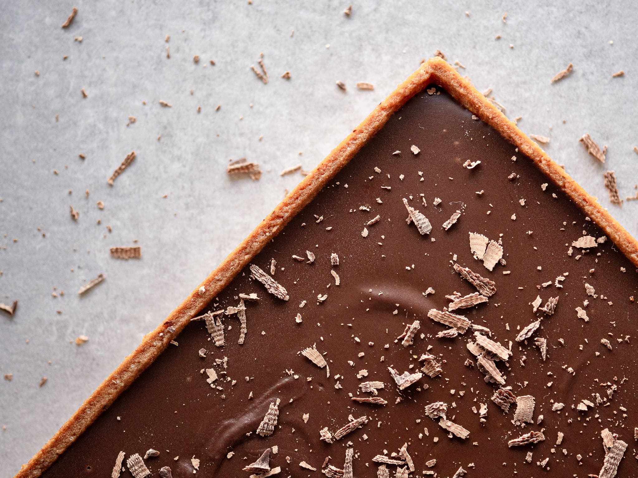 une tarte au chocolat vegan avec des copeaux de chocolat et une pate brisée vegan maison